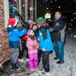 A family stand outside in the snow after the party